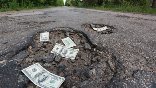 Dollar bills in the potholes on road